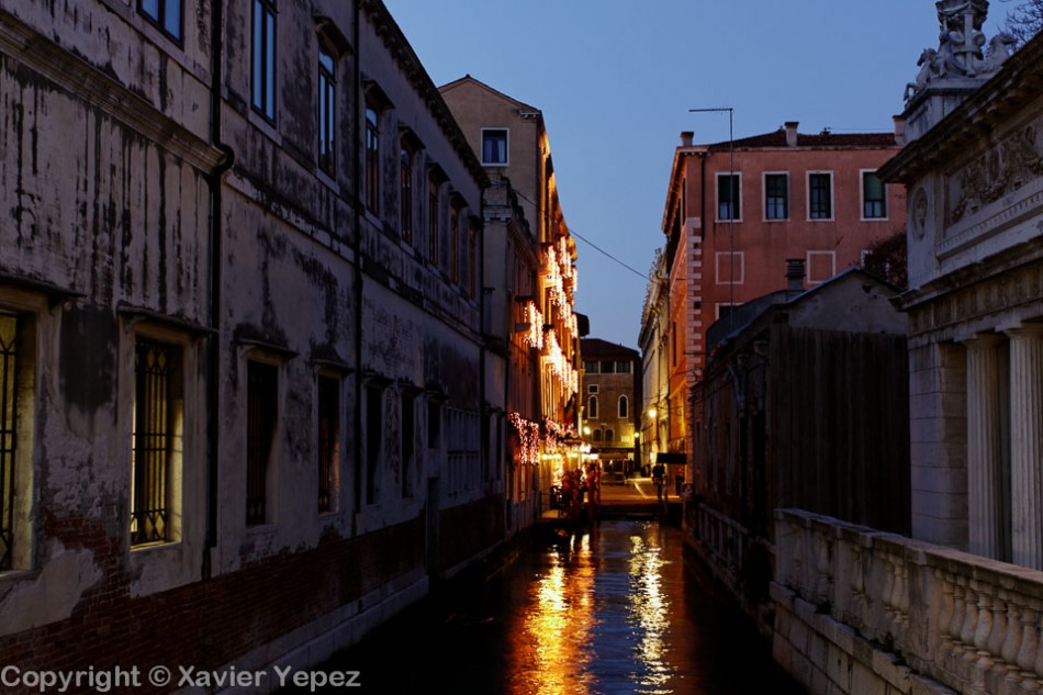 An empty canal at night, with reflected light from lanterns, Venice, Italy