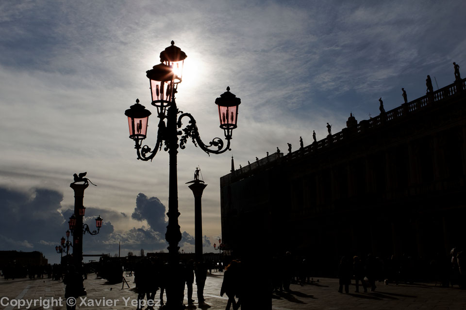 Silhouettes of lanterns against the sun in Piazza San Marco, Venice, Italy