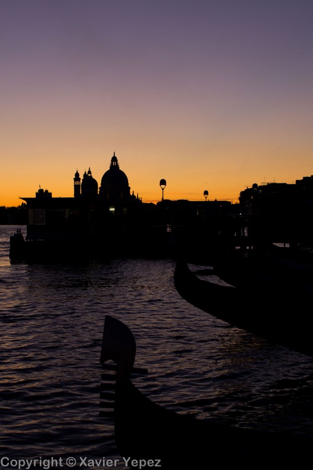 Silhouettes of gondolas and a church in a sunset in Venice, Italy